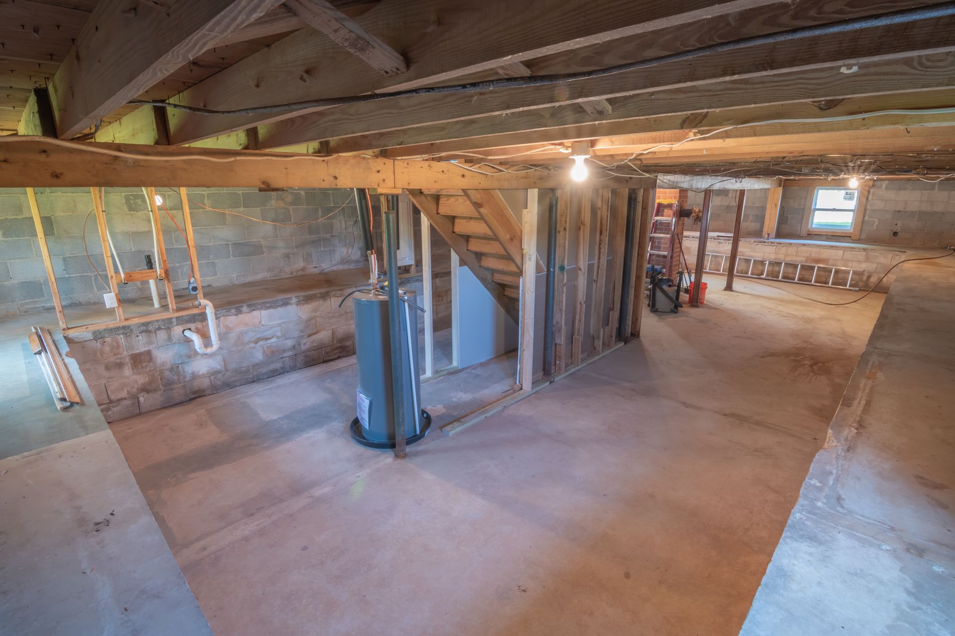 Unfinished below-grade room with exposed concrete and a window
